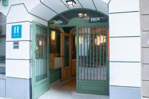 哈卡Hotel Alda Jolio Jaca的绿色门的建筑物入口