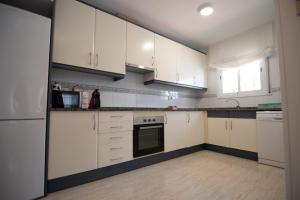 利乌玛Casa Riu Avall的厨房配有白色橱柜和炉灶烤箱。