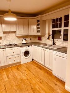 伦敦德里Waterside Star的厨房配有白色橱柜和洗衣机。