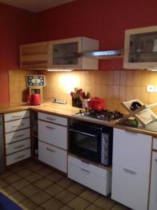 尼姆Les Trois Rois的厨房配有白色橱柜和炉灶烤箱。