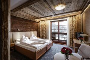 卡尔帕奇Alpejski Boutique Hotel的一间卧室配有一张床、一张书桌和一个窗户。