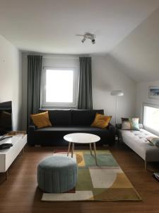 摩拉瓦托普利采Apartment Green Paradise的客厅配有黑色沙发和桌子