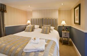 纽敦Bettws Hall Accommodation的一间酒店客房,配有一张带毛巾的床