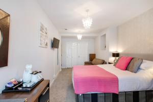托基特里劳妮酒店的一间卧室配有一张带粉色毯子的大床