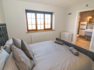 卡纳芬Afon Rhos Bach的卧室配有带枕头的床铺和窗户。