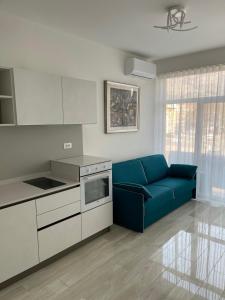 博尔扎诺CASA VITTORIA - SIEGESHAUS的客厅设有蓝色沙发,厨房设有
