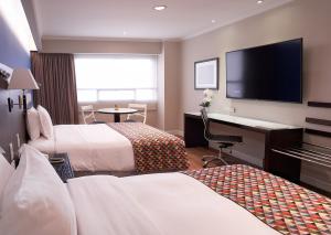 瓜亚基尔奥罗沃德瓜亚基尔酒店的酒店客房设有两张床、一张桌子和一台电视。