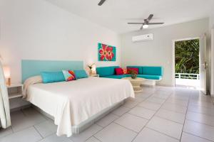 萨尤利塔AzulPitaya Beach Front Hotel in Sayulita的一间卧室配有一张大床和一张蓝色的沙发