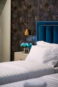 地拉那Rama's Hotel的一间卧室配有一张蓝色床头板的床