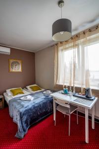 华沙卡瓦别墅酒店的一间卧室配有一张床、一张桌子和一张书桌