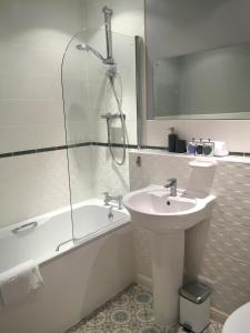 波蒂斯黑德Liberty Suite Apartment的一间带水槽、浴缸和淋浴的浴室