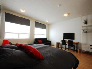 维克火山酒店 的一间卧室配有一张带红色枕头的床和电视。