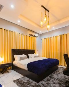 阿克拉The Avery Suites, East Legon的一间卧室配有一张带黄色窗帘的大床