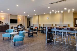 大瀑布城MainStay Suites Great Falls Airport的一间设有蓝色桌椅的餐厅和一间酒吧