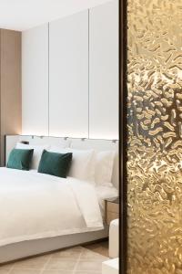 深圳深圳安琰酒店的卧室配有白色的床和金色墙壁