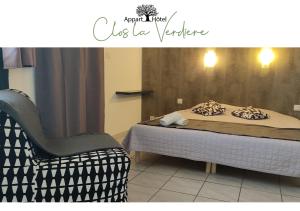 VelauxLe Clos la Verdière的一间卧室配有一张床和一把椅子,旁边是