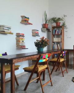洛斯·亚诺斯·德·阿里丹Hostel Vagamundo的一张木桌、椅子和墙上的书籍