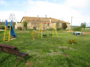 La Pera马斯杜兰乡村民宿的庭院设有带秋千和长凳的游乐场