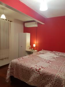 新彼得罗波利斯QUARTO Jardim da Serra的一间卧室设有红色的墙壁、一张床和镜子