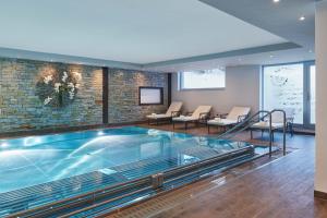 采尔马特SCHLOSS Zermatt - Active & CBD Spa Hotel的酒店大堂设有按摩浴缸和椅子