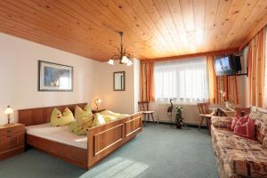 齐勒谷地里德Haus Schroll的一间卧室配有一张床和一个沙发