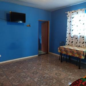 巴鲁埃里Quarto Duplo Confort的蓝色的房间,设有桌子和墙上的电视