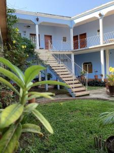 San Pedro PochutlaHotel Izala的庭院内带楼梯的白色房子