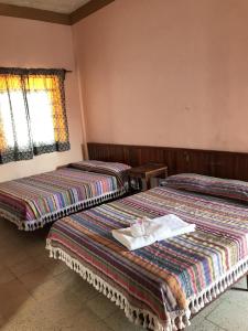 San Pedro PochutlaHotel Izala的两张位于酒店客房的床,配有毛巾