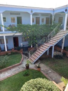 San Pedro PochutlaHotel Izala的一座白色的房子,在院子里有楼梯