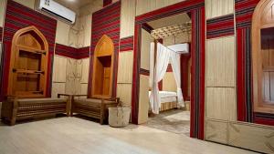 马斯喀特Fort Guesthouse نُزل القلعة的客房设有带镜子和床的卧室