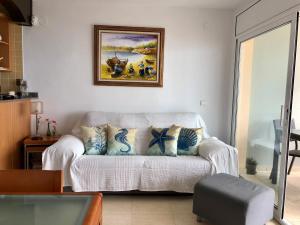 拉皮内达PINEDA BEACH 1a línea de mar & parking的客厅配有沙发和墙上的绘画