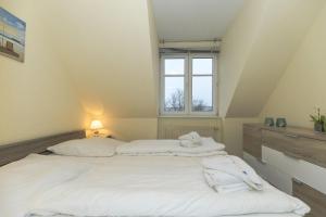 奥斯赛拜-屈隆斯博恩Strandschloesschen-Haus-II-WE-20-9720的阁楼间设有两张床,设有窗户