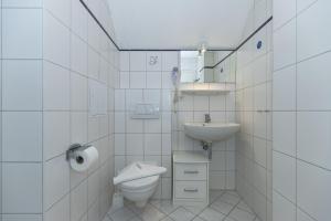 奥斯赛拜-屈隆斯博恩Strandschloesschen-Haus-II-WE-20-9720的白色的浴室设有卫生间和水槽。