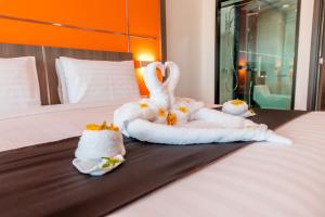 北芭堤雅The Proud Hotel Pattaya - SHA Certified的床上用毛巾制成的两天鹅