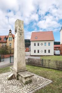 海尔巴德海利根斯塔特Am Landhof Heiligenstadt Ferienwohnung的白色建筑前的石头纪念碑