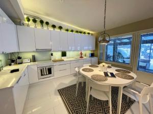奥卢Design Guesthouse Laanila的厨房配有白色橱柜和白色的桌椅