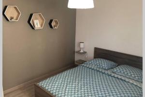 布拉尼亚克Appartement cosy avec jardin à Blagnac.的一间卧室配有一张带绿色棉被的床