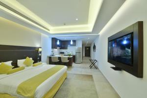 安曼Downtown Hotel Apartments的一间卧室配有一张大床和一台平面电视