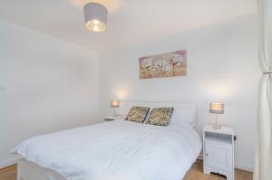 ThamesmeadKentmere Apartment Thamesmead的卧室配有白色的床和两盏灯。