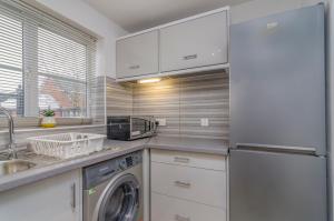 ThamesmeadKentmere Apartment Thamesmead的厨房配有洗衣机和烘干机