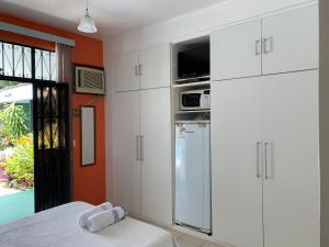 马瑙斯Amanda Suites的厨房配有白色橱柜和冰箱。