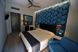 科孚镇Corfu Mare Hotel -Adults only的一间卧室设有一张大床和蓝色的墙壁