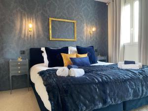 BaslyLe Clos de la Barre的蓝色卧室配有一张带枕头的大床