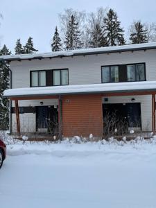伊马特拉Дом у спа-центра и озера的前面的地面上积雪的房子