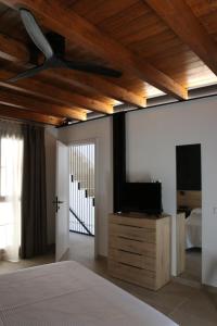 Les Coves de VinromaUn moment, casa rural de 4 estrellas的一间卧室设有一张床,天花板上配有电视