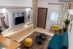 沃洛斯Jolie maison Volos的客厅配有电视和桌椅