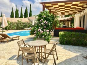 库克里亚Villa Panorama - Stunning views in villa with hot tub, pool, garden的池畔露台配有桌椅