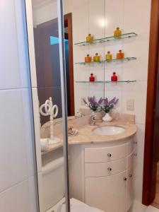 格拉玛多Resort com Natureza no Centro的一间带水槽和玻璃淋浴的浴室