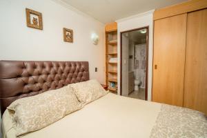 伊基克阿波罗卡弯查公寓的一间卧室配有一张带棕色皮革床头板的床