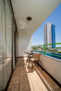 伊基克阿波罗卡弯查公寓的阳台配有桌子,享有建筑的景致。